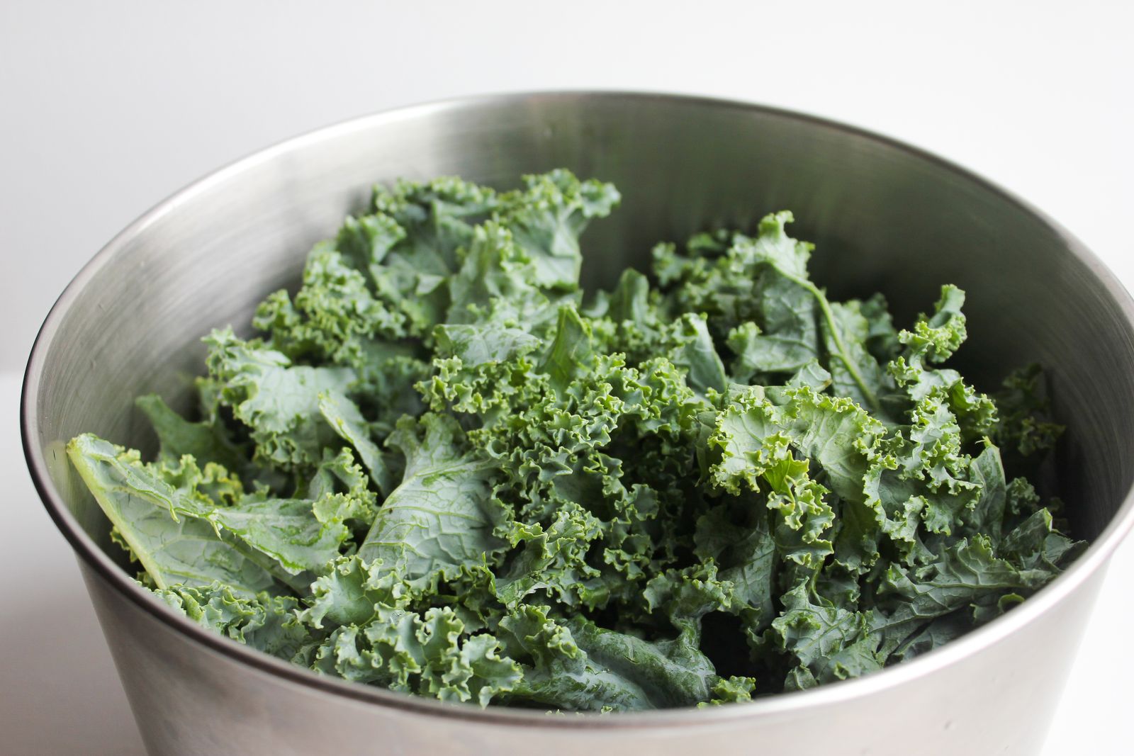 Bowl of fresh curly kale leaves