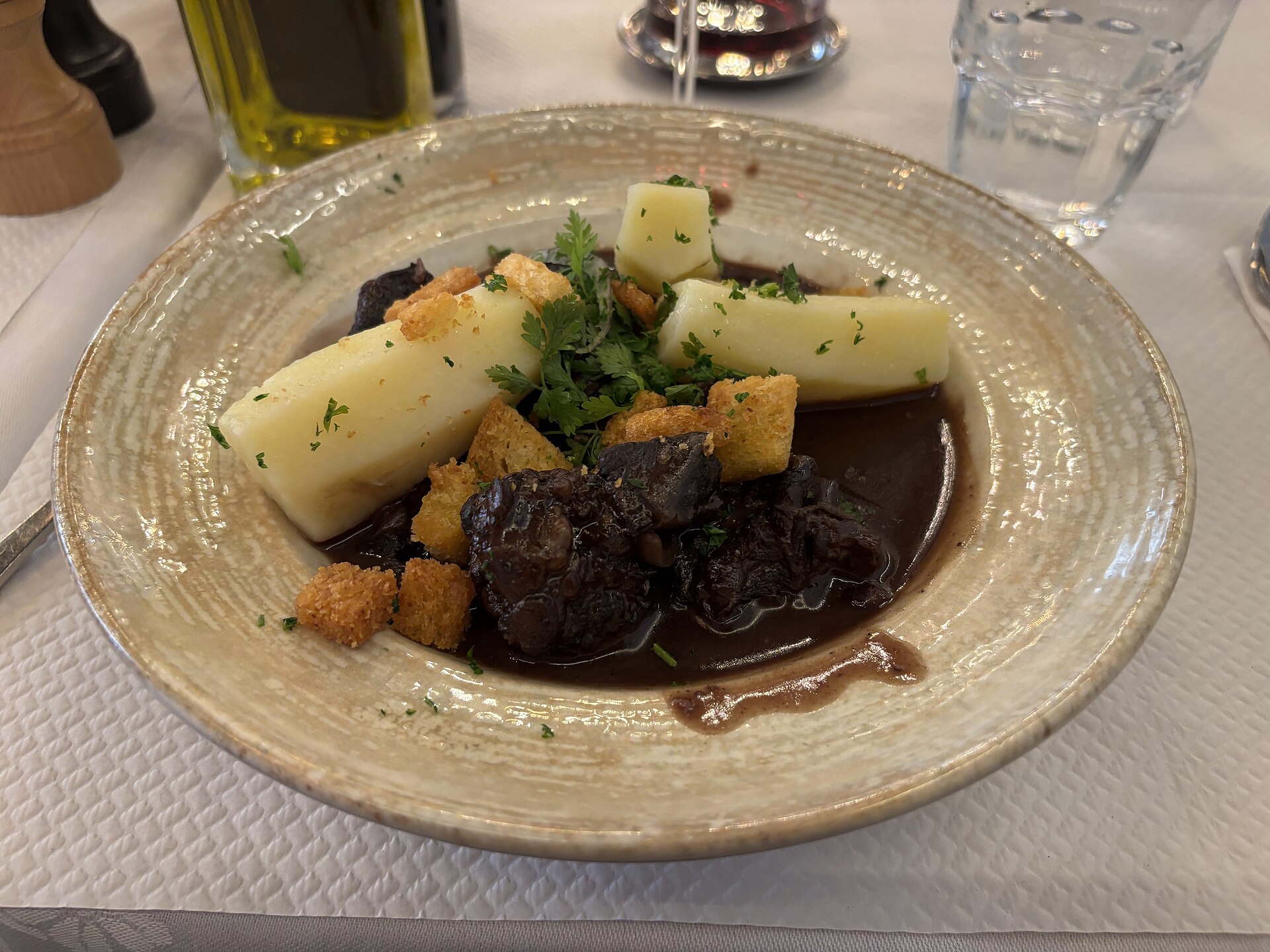 Beef braised in red wine sauce with potatoes on a plate