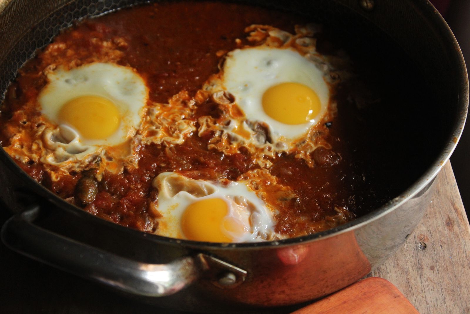 Eggs baked in a skillet of tomato and vegetable sauce