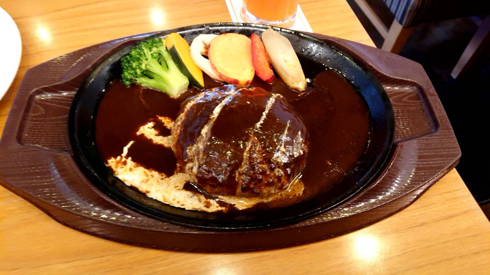 Cheese-stuffed Salisbury steak in dark gravy on a sizzling iron plate