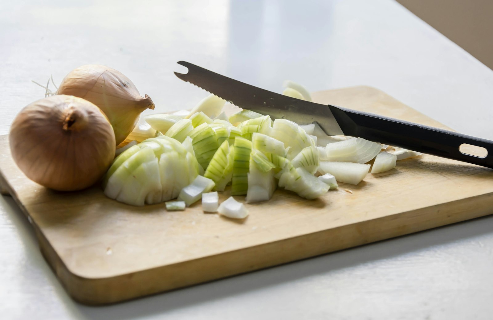 Freshly chopped onion on a wooden cutting board