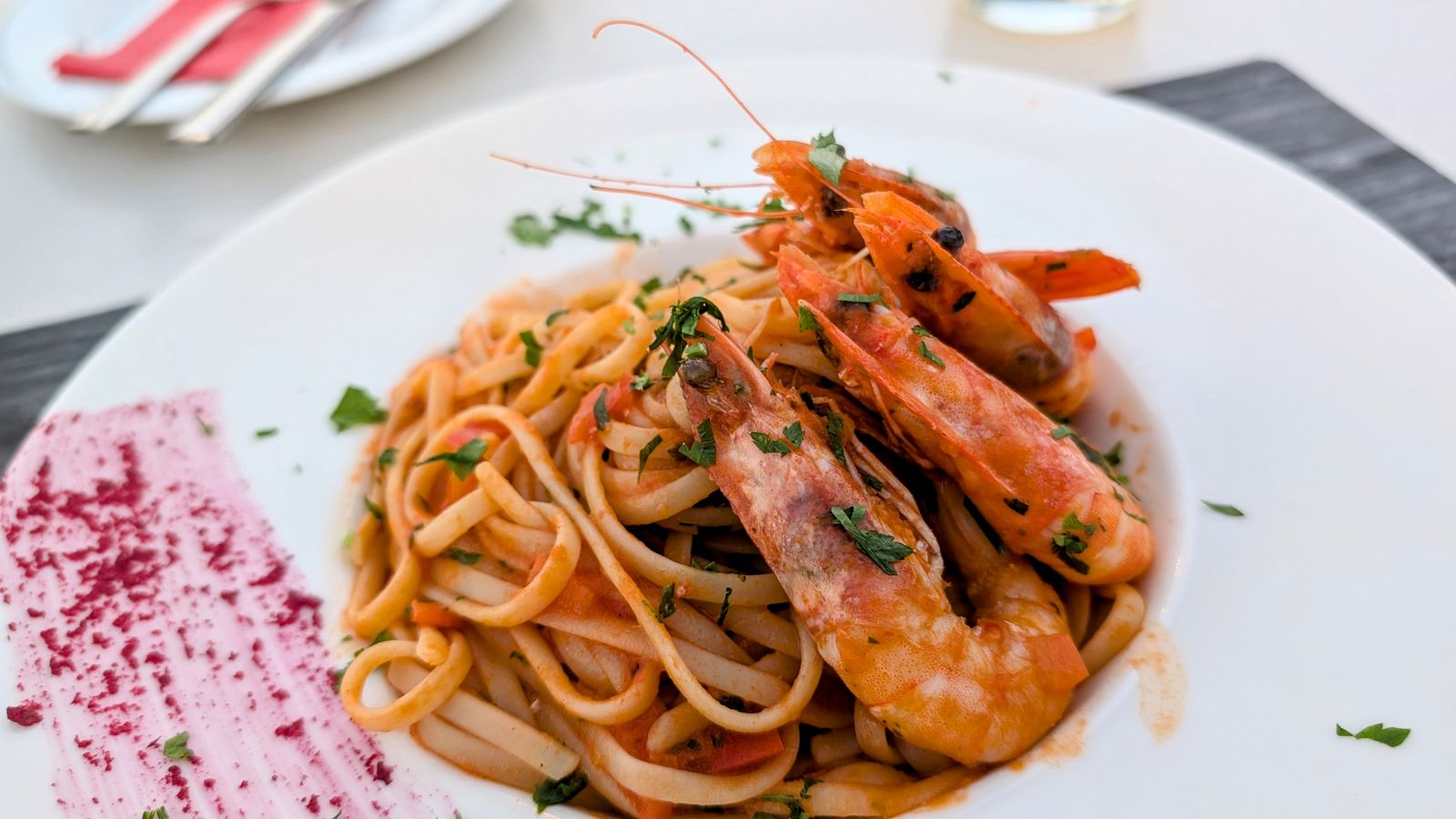 Spaghetti with shrimp in tomato sauce on a white plate