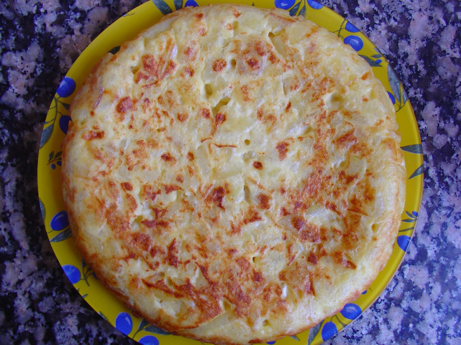Golden Spanish potato omelet on a yellow plate
