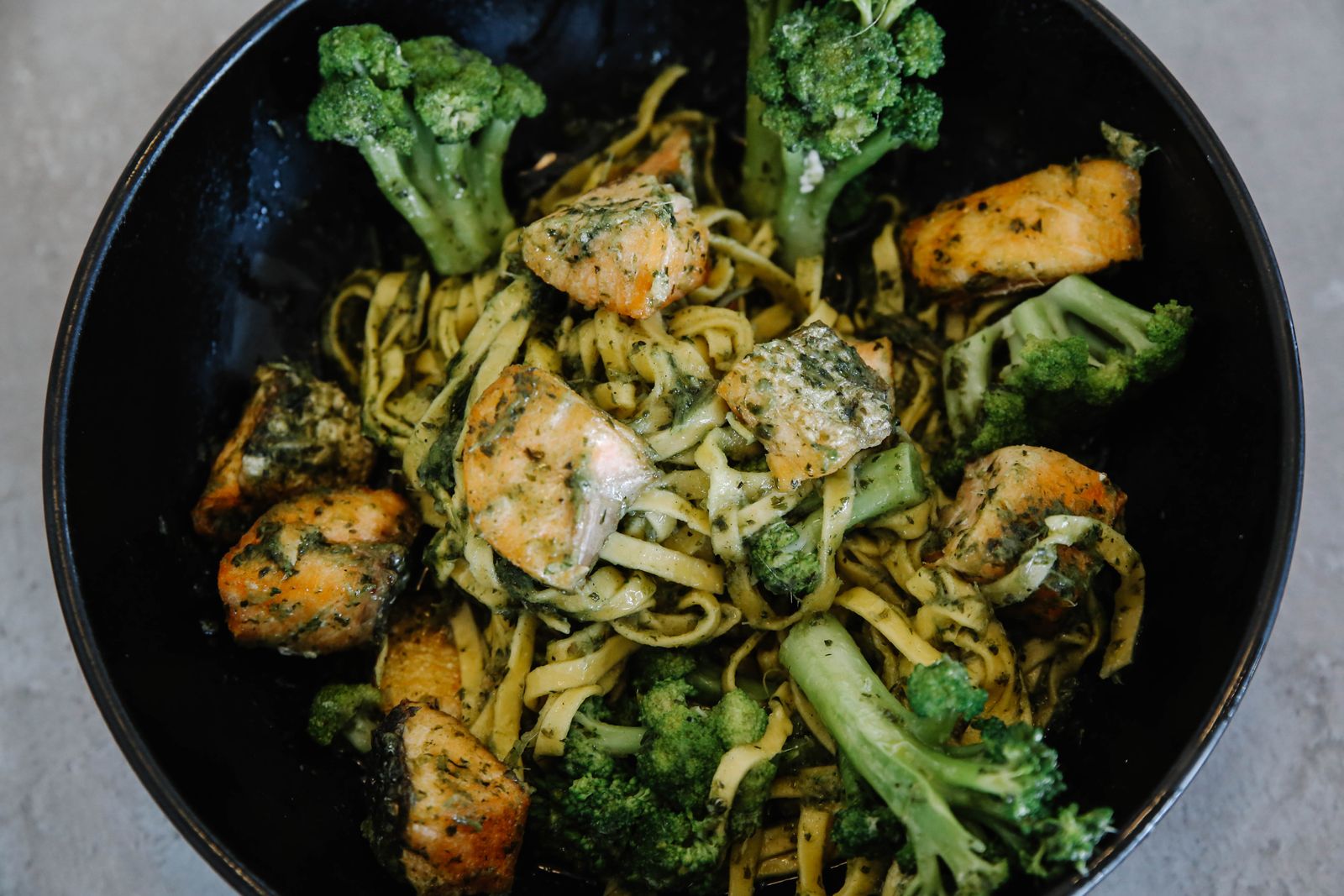Creamy pasta with broccoli in a black bowl