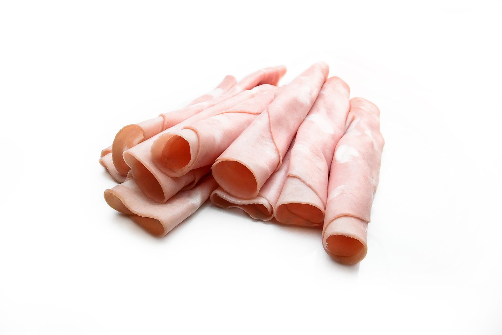 Thin slices of cooked ham on a white background