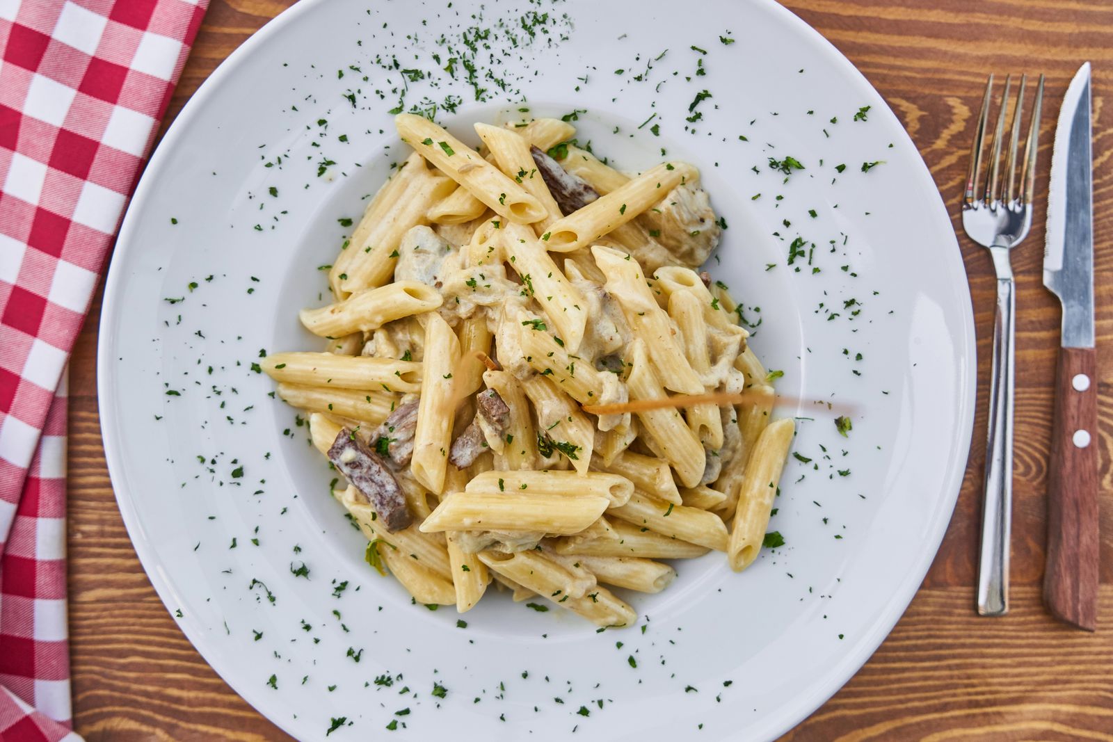 Plate of creamy pasta from above on a white table