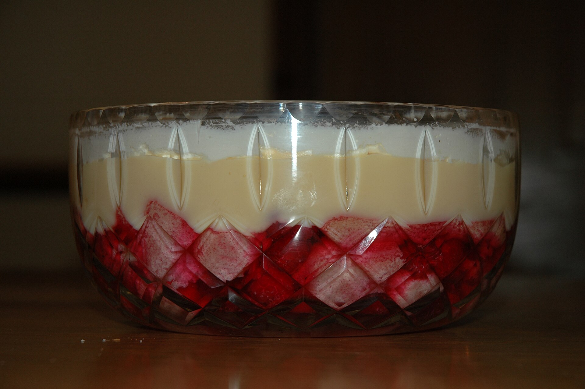 Layered holiday trifle with jelly, custard and cream in a glass bowl