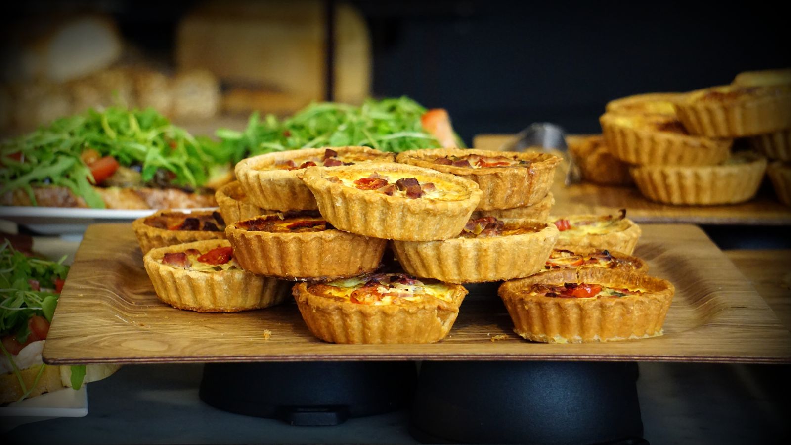 Mini quiches on a wooden tray, easy Paul Hollywood party food for a crowd