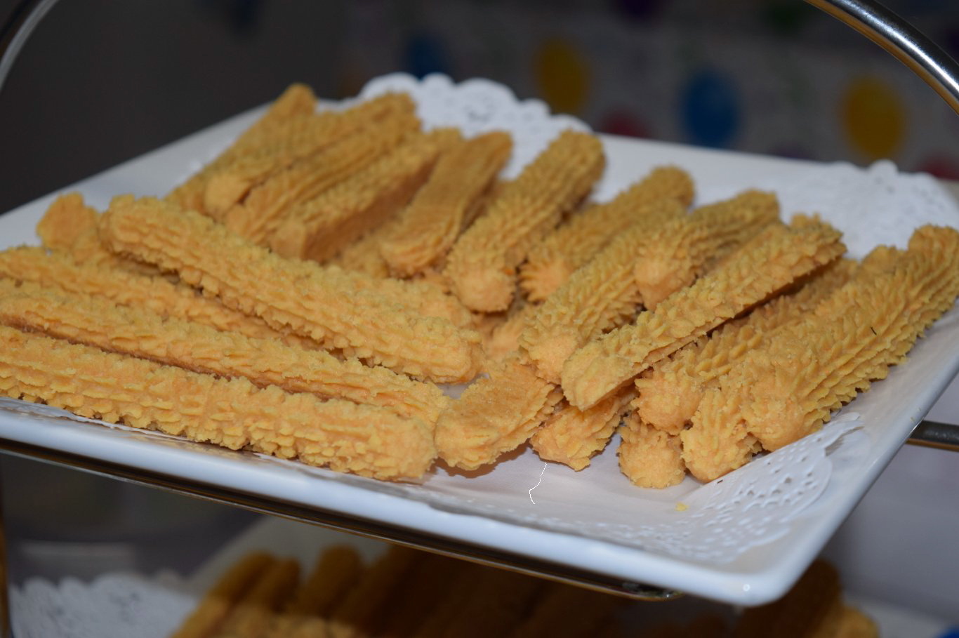 Crisp cheese straws piled on a white plate