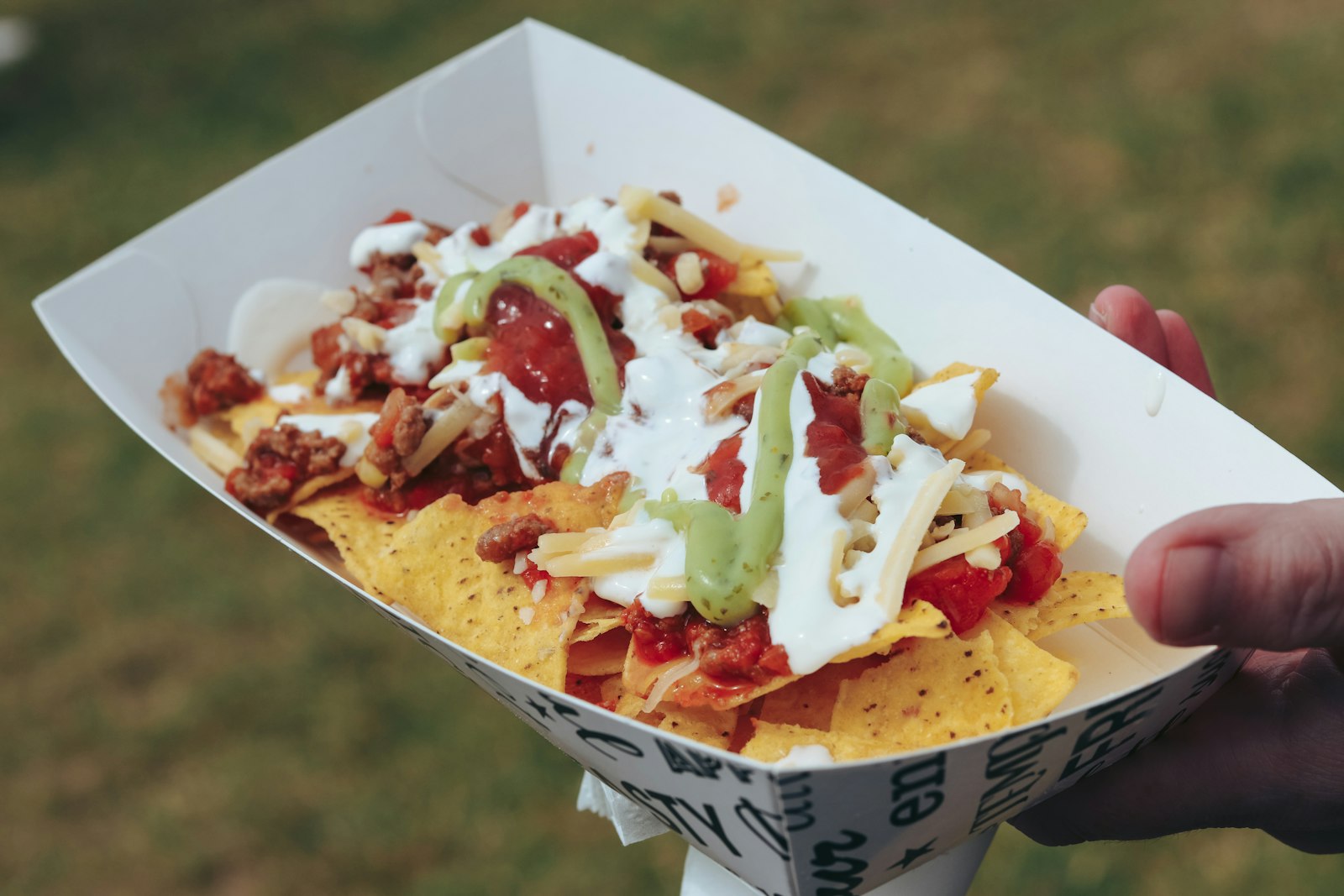 Sheet pan nachos topped with pulled meat and sour cream