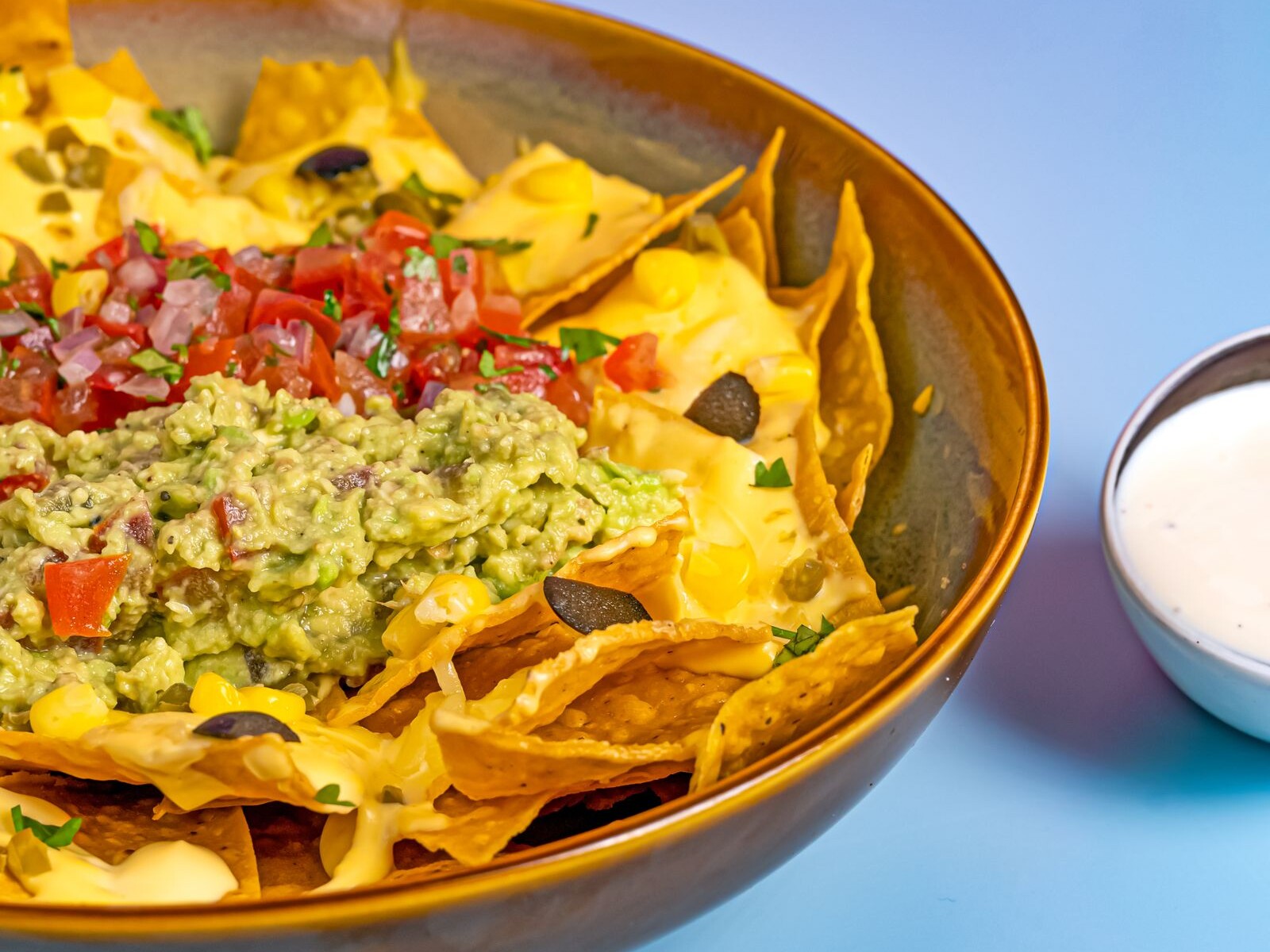 Loaded sheet pan nachos with guacamole, pico de gallo and cheese