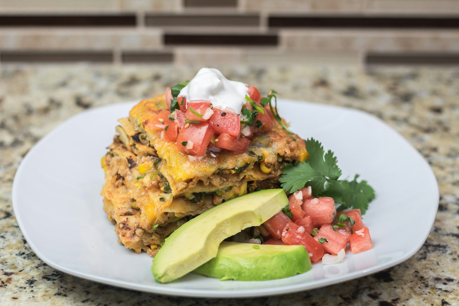 Square of layered Mexican tortilla casserole with melted cheese