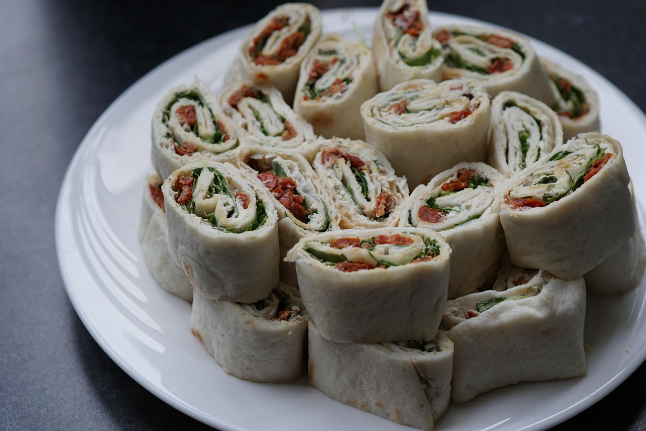 Sliced ham and cream cheese pinwheels on a serving plate