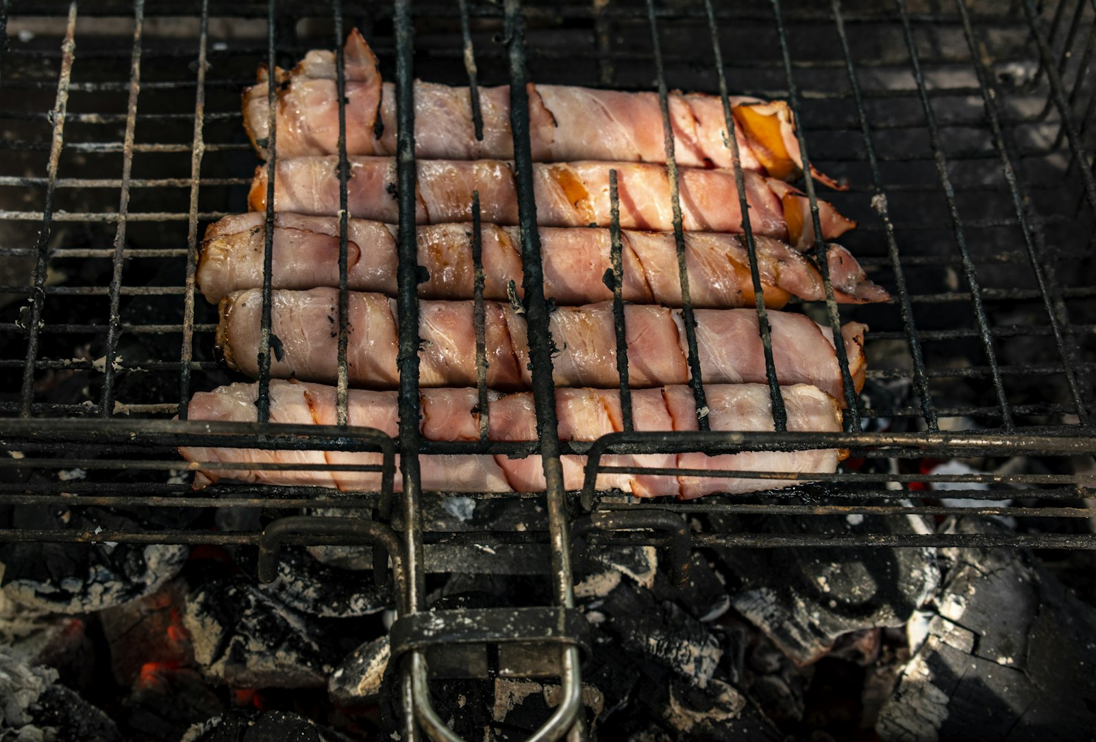 Bacon wrapped bites cooking on a grill