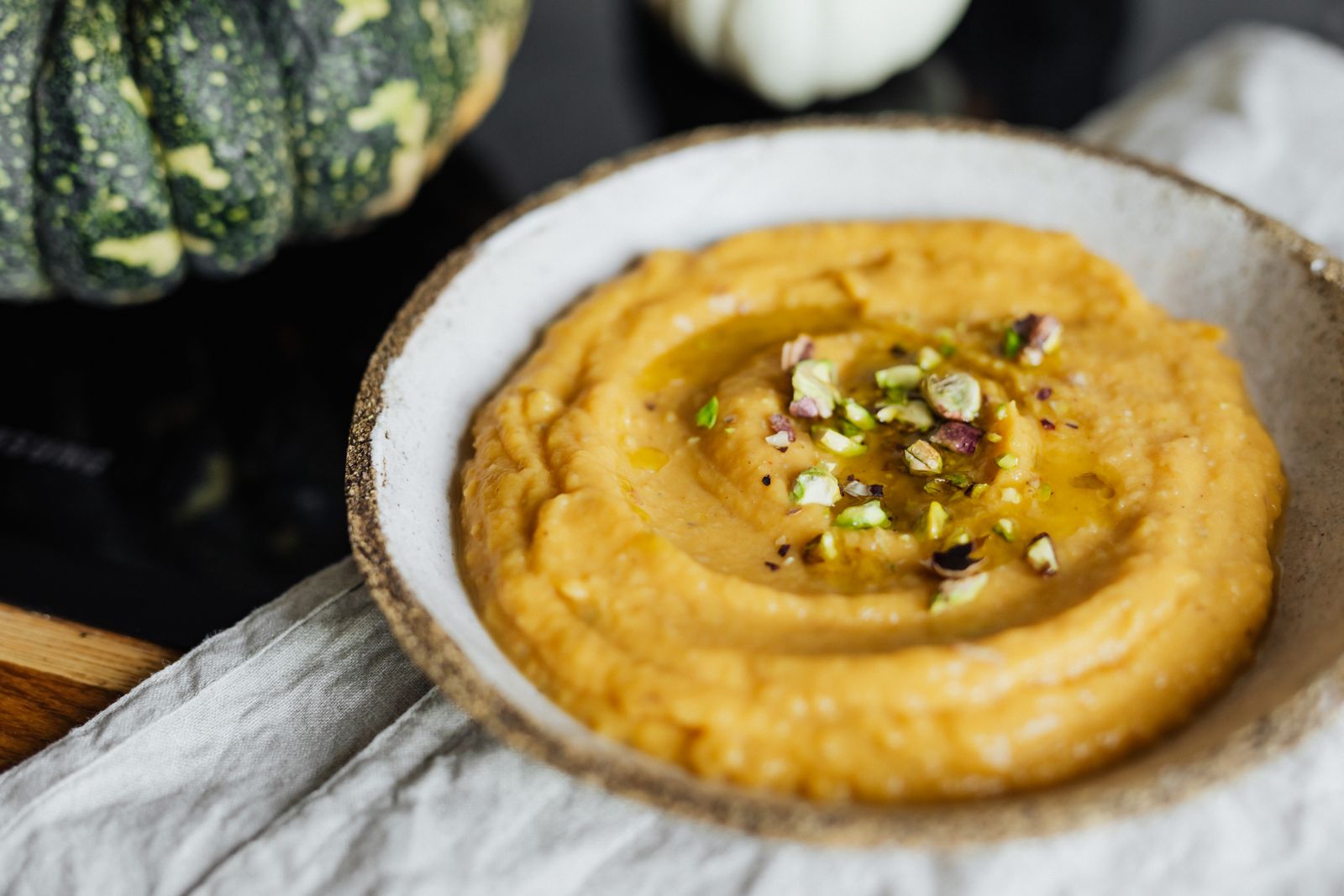 A bowl of creamy orange pumpkin hummus