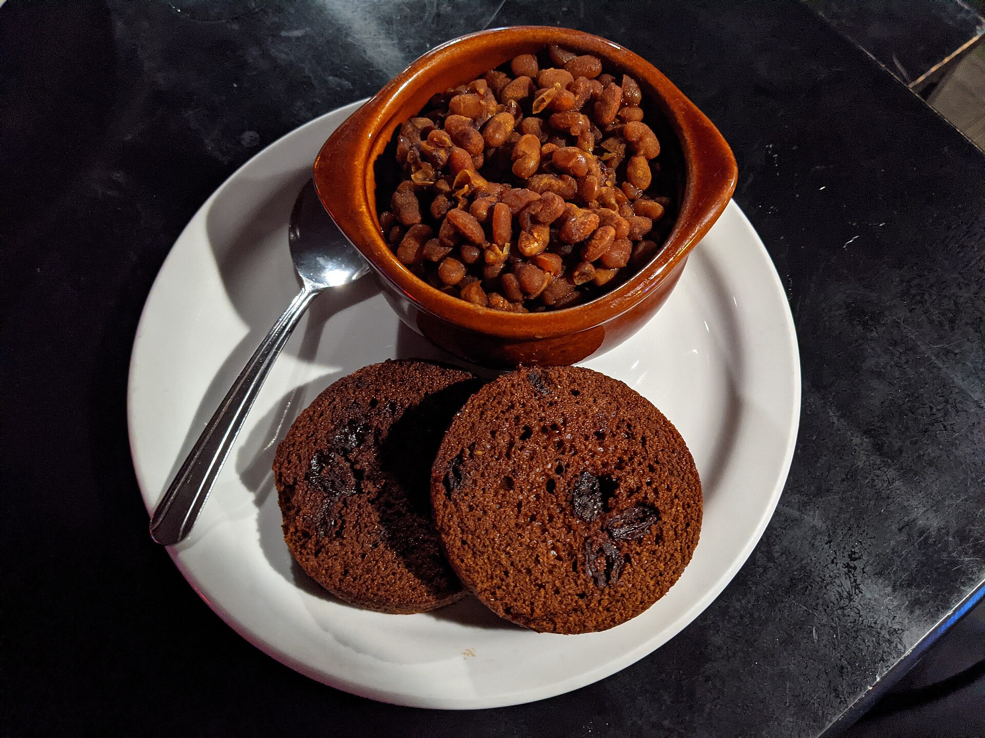 A crock of baked beans served with brown bread
