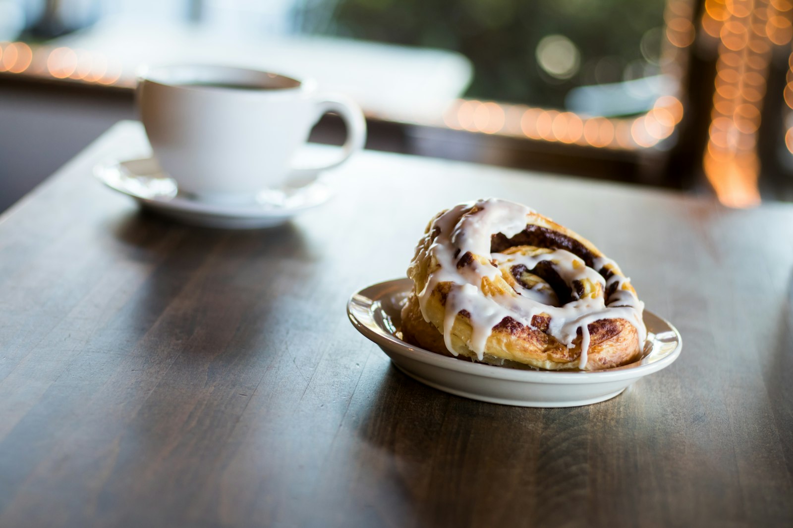 A frosted cinnamon roll on a plate