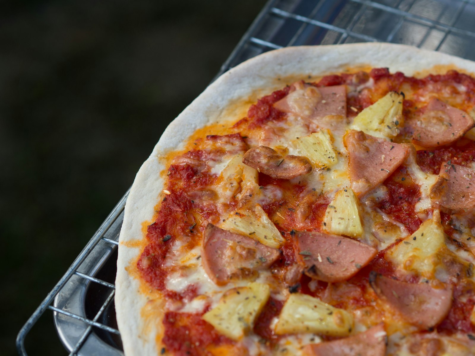 A baked Hawaiian pizza with ham and pineapple