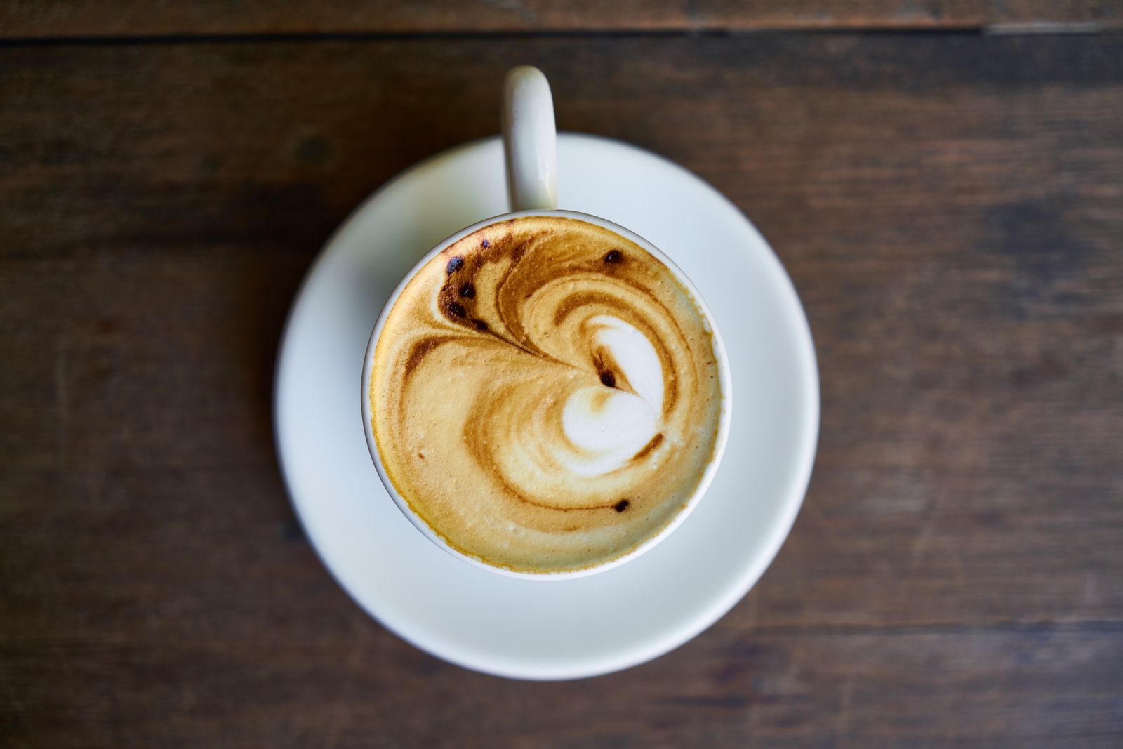 Latte art in a white cup on a saucer