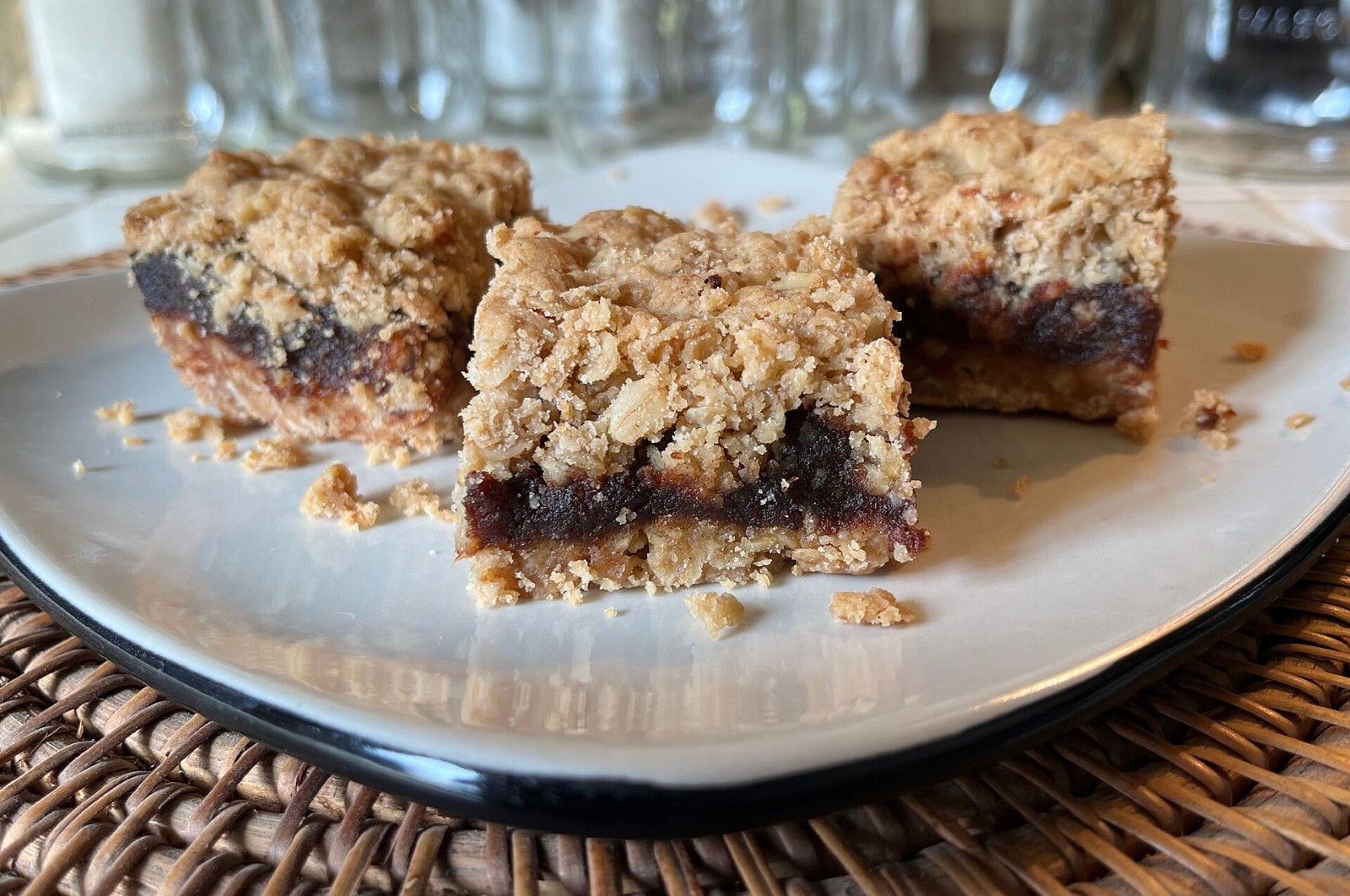 Oat crumb date squares cut into neat bars on a white plate