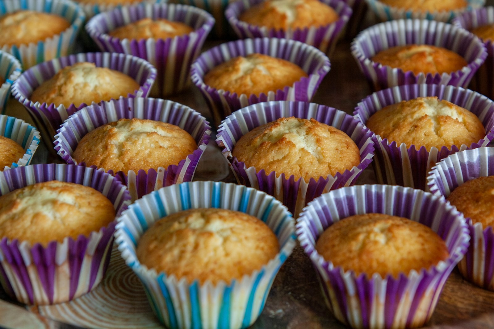 Golden muffins baked in striped paper cupcake liners