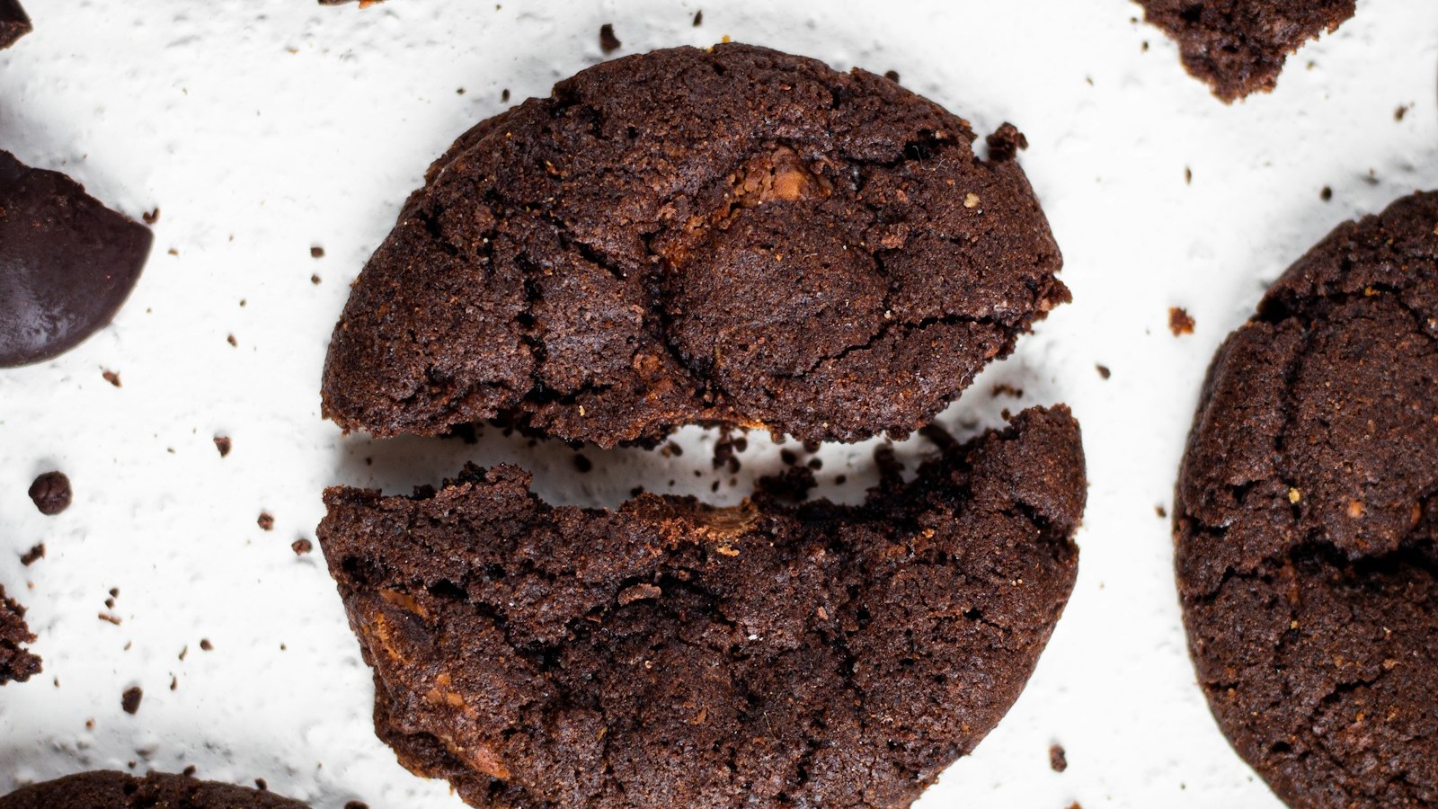 Fudgy flourless cookies with crackly chocolate tops on parchment