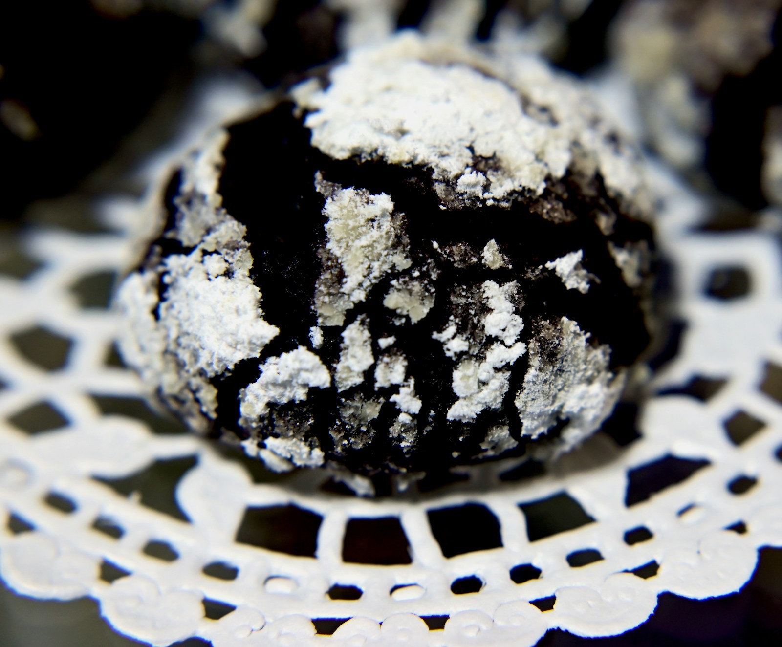 Chocolate crinkle with powdered sugar on a lace doily