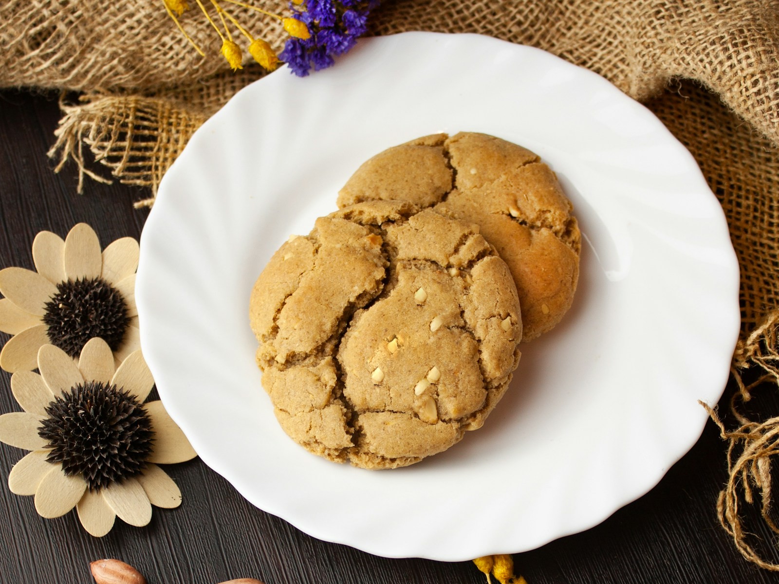 Two crackly peanut butter cookies on a white plate
