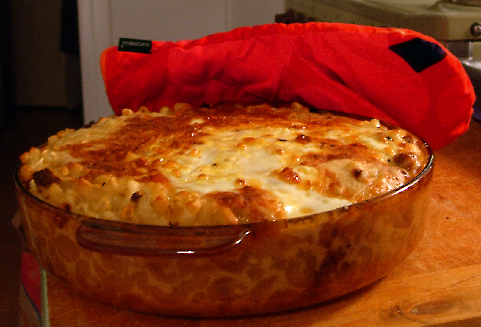 A golden baked macaroni casserole in a glass dish