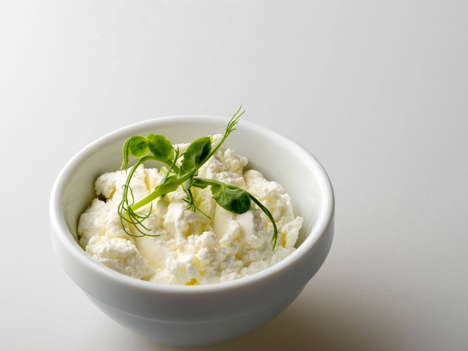 A white bowl of creamy cottage cheese, the surprise topping on Hailey Bieber chicken meatballs