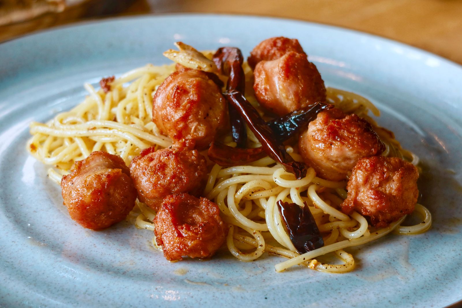 Meatballs over spaghetti with tomato sauce and herbs
