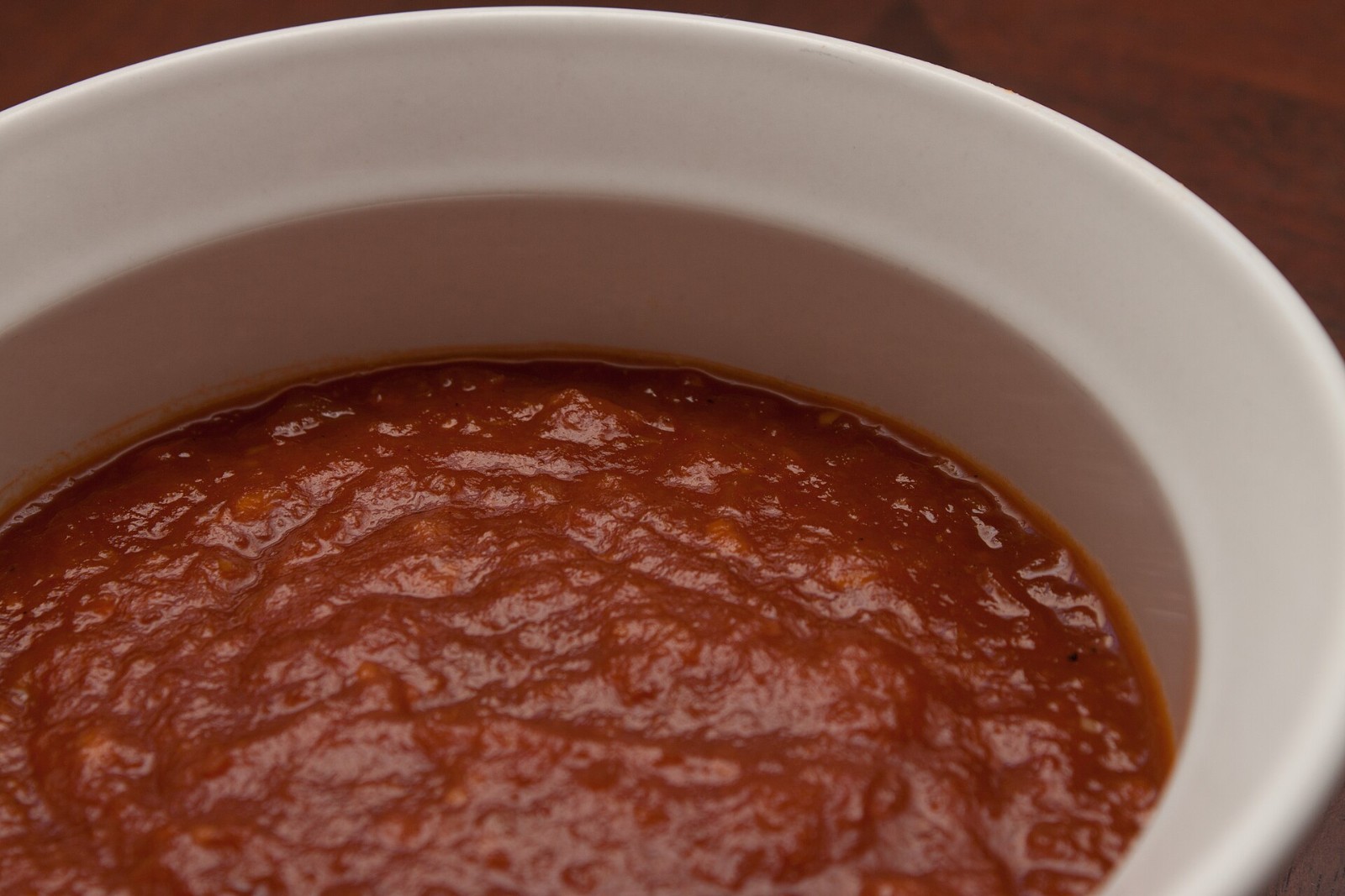 Glossy apricot bourbon homemade BBQ sauce in a white bowl