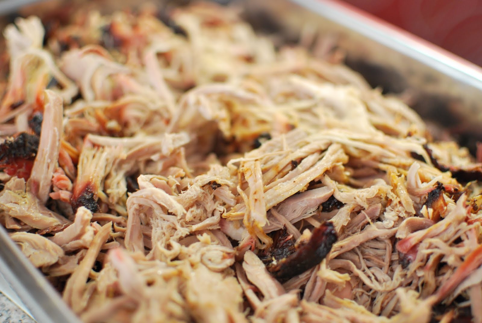 A tray of tender pulled pork ready for a thin vinegar and pepper sauce