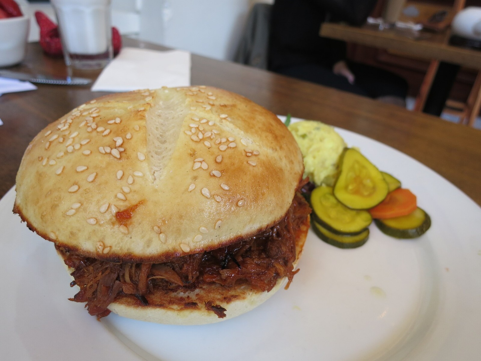 Pulled pork sandwich on a soft bun with tangy Memphis style sauce and pickles