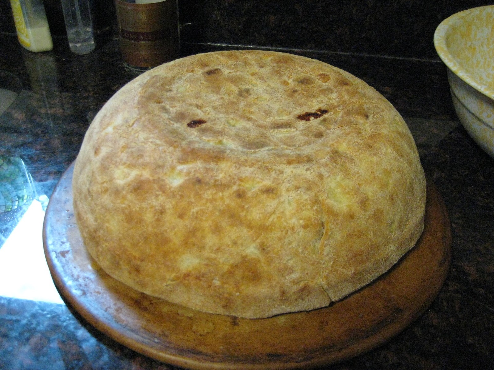 A golden domed timballo Italian baked pasta drum on a wooden board
