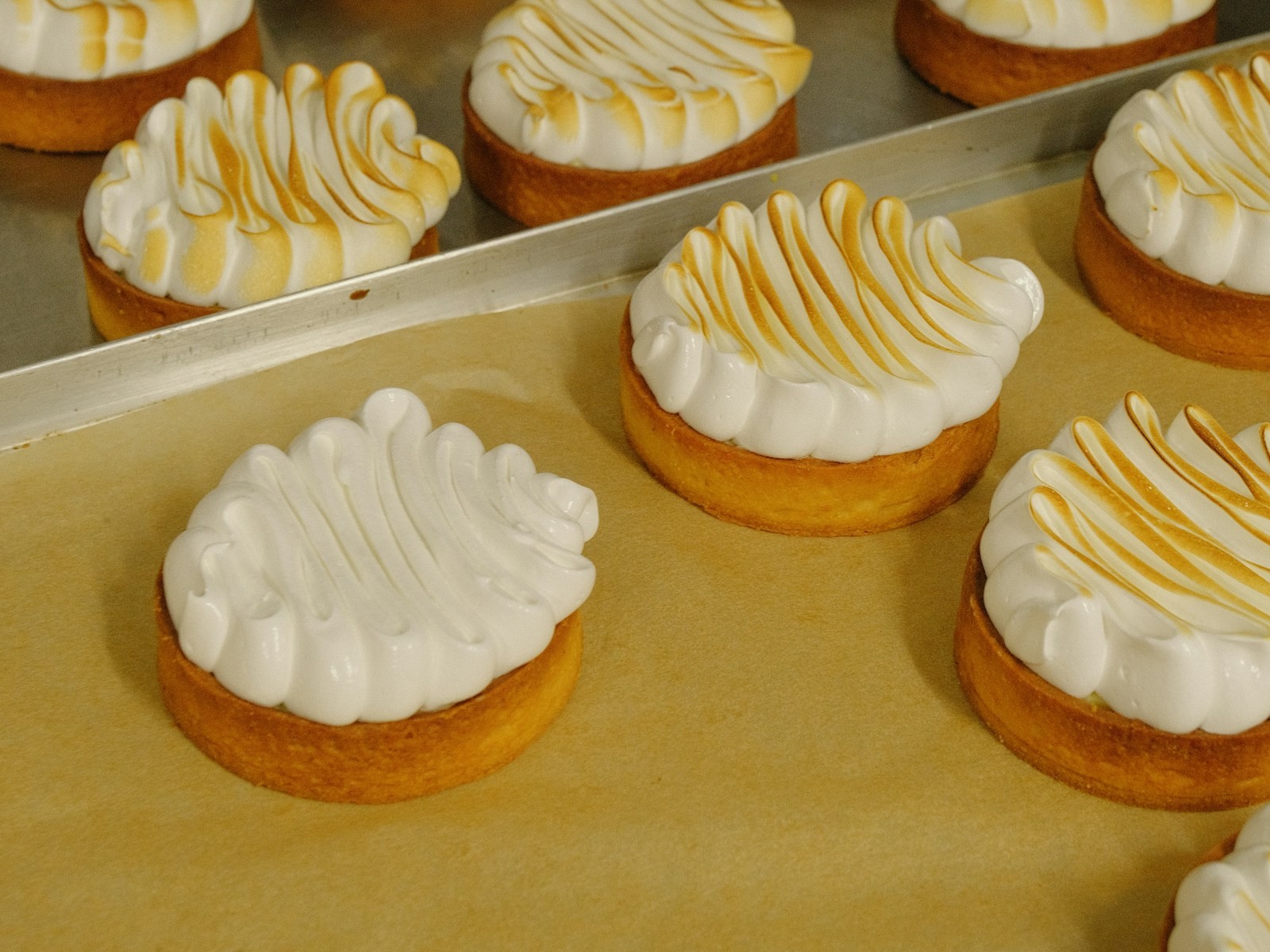 Tray of mini tartlets topped with toasted meringue swirls