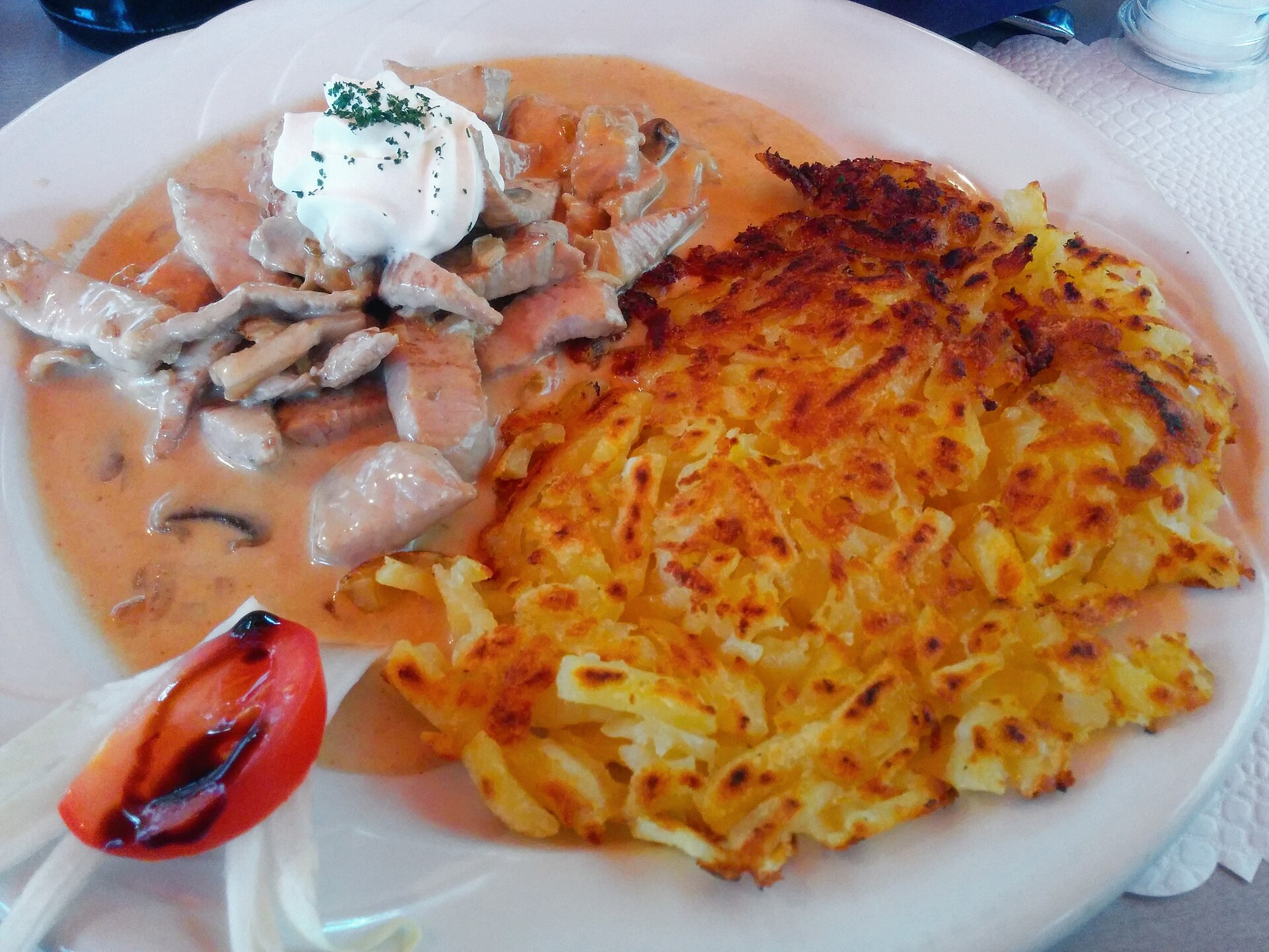 A golden Swiss rosti served with creamy veal