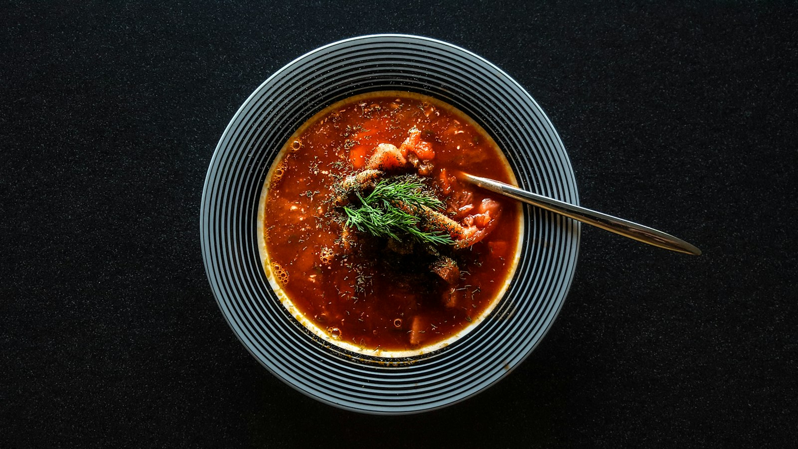 Bowl of taco broth with beef, beans and toppings