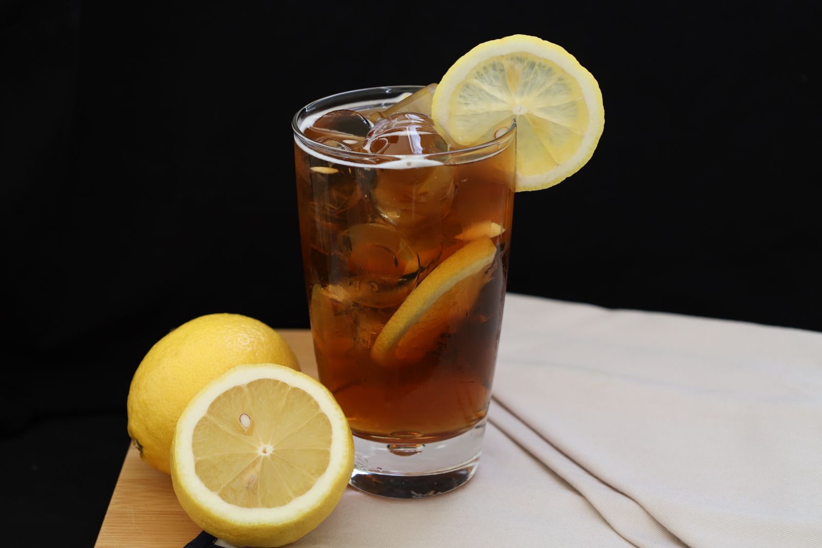 Iced tea with lemon slices on a wooden board