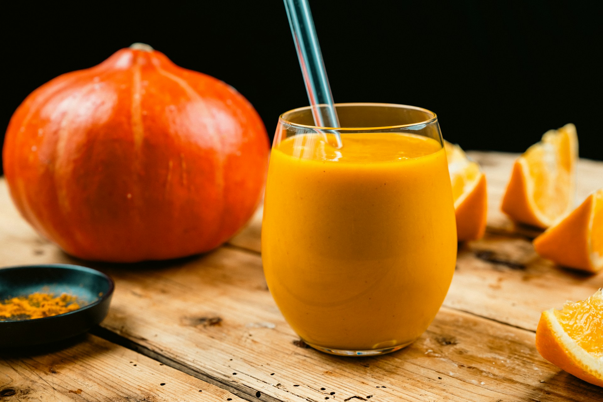 High-protein pumpkin recipes: orange pumpkin smoothie next to a small pumpkin