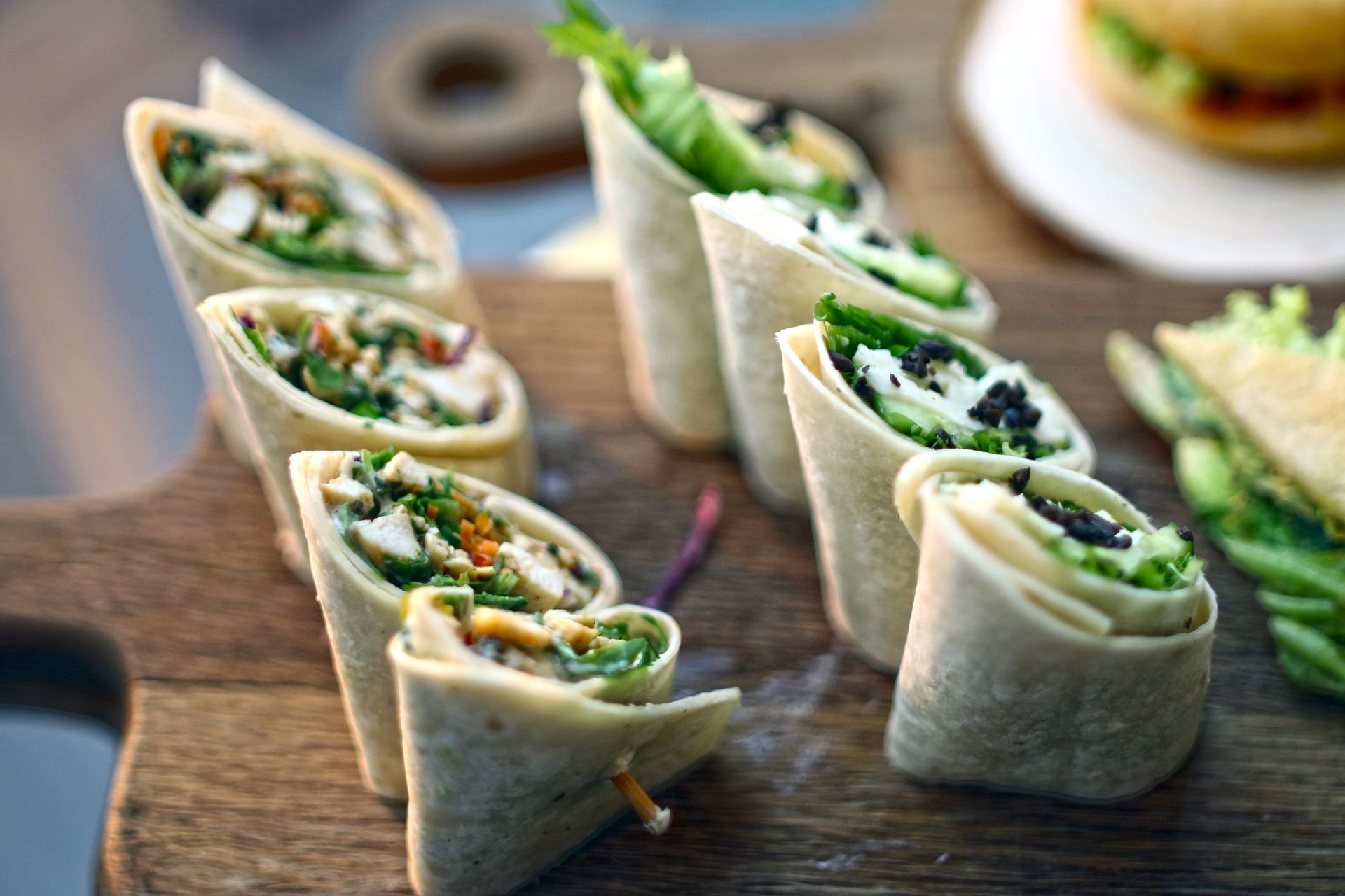 Christmas pinwheels: tortilla wraps with greens sliced on a wooden board