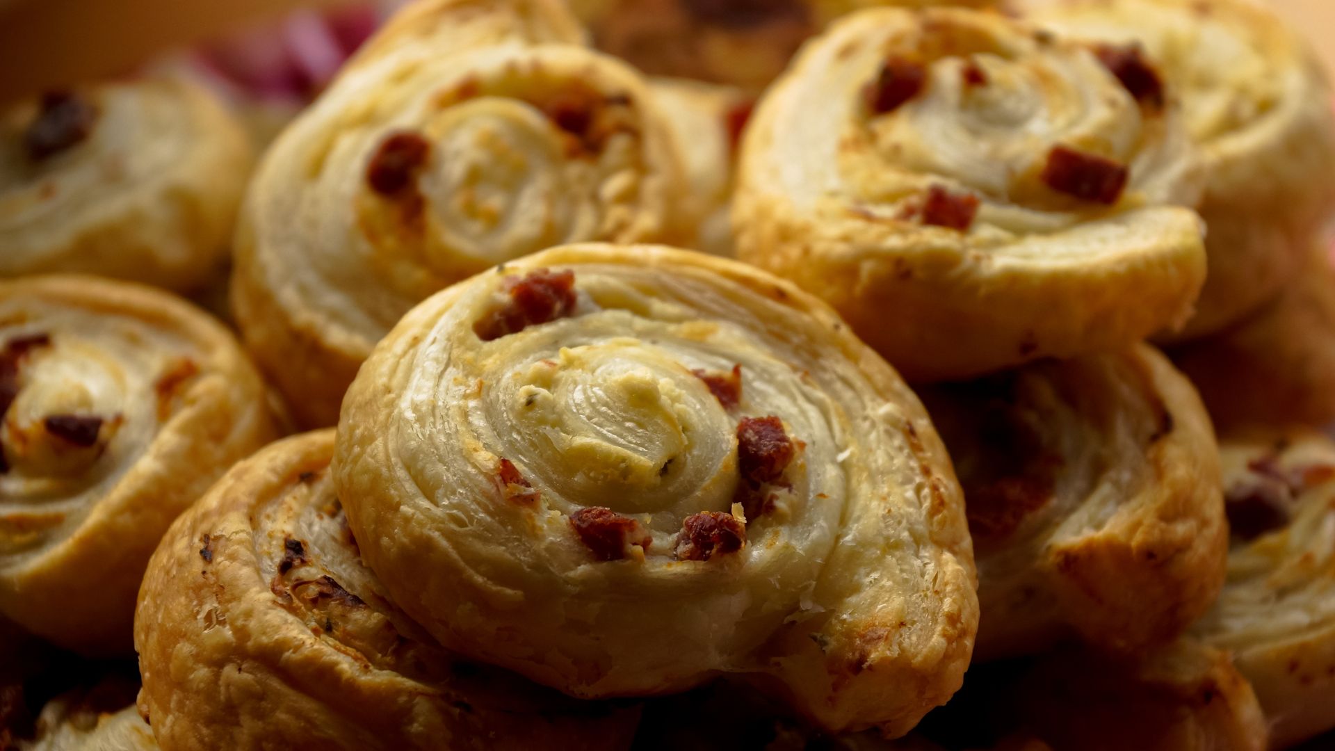 Golden puff pastry spirals with red pepper pieces