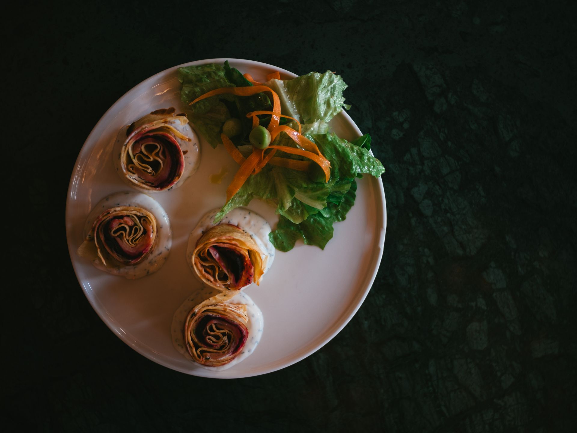Christmas pinwheels: smoked salmon roll slices with greens on a plate