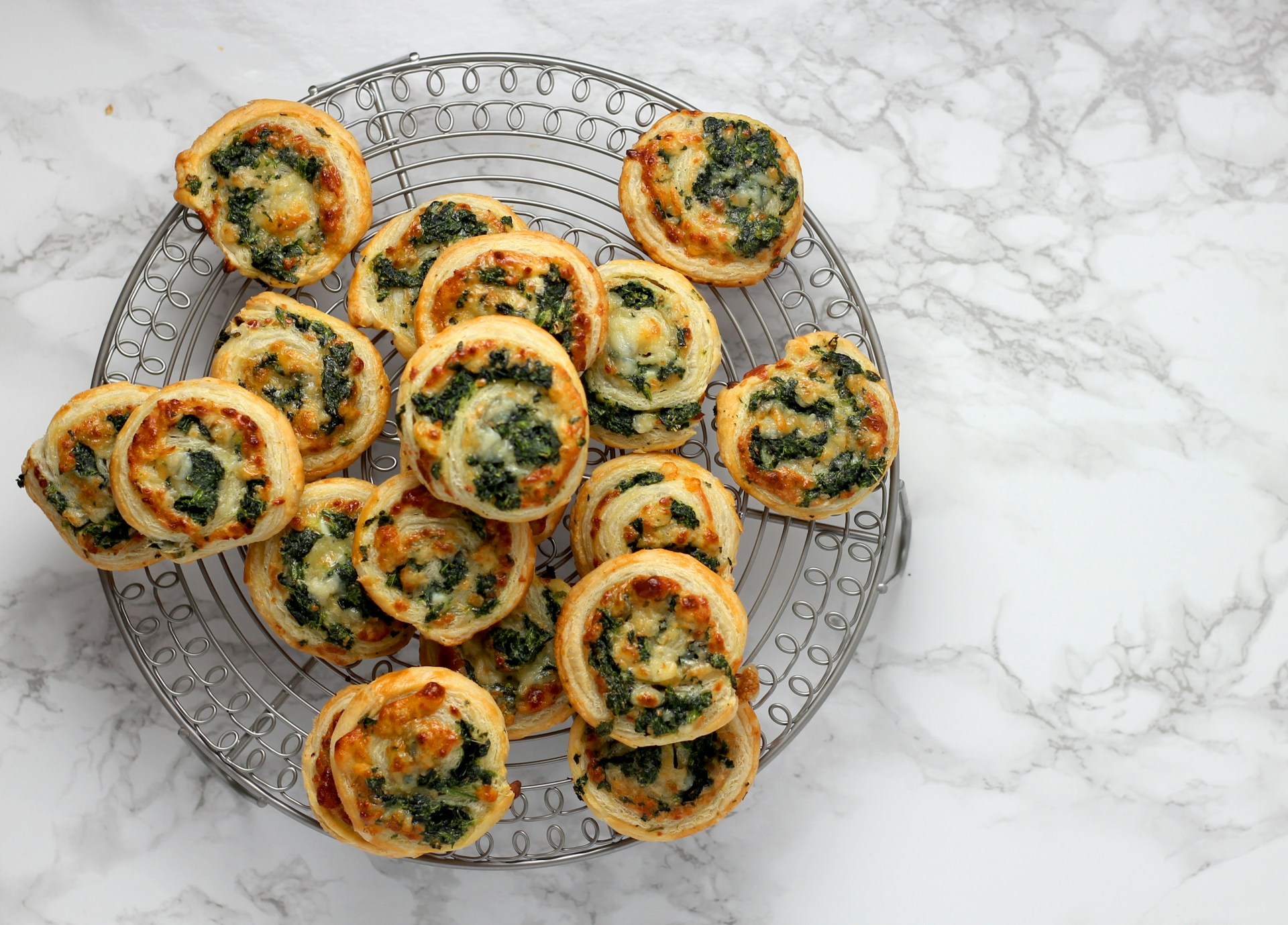 Christmas pinwheels: spinach puff pastry pinwheels on a wire rack