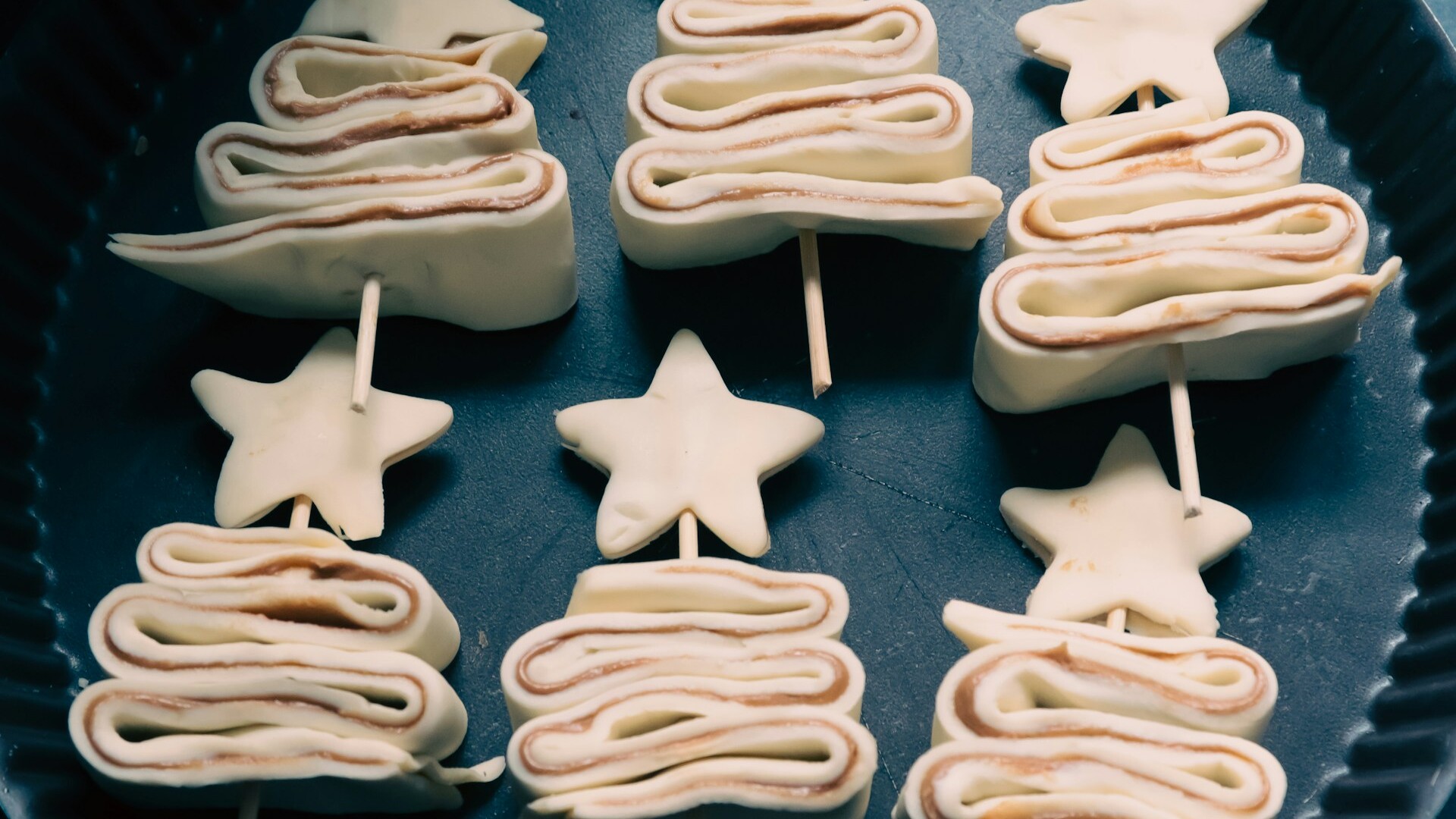 Puff pastry tree shapes on skewers before baking