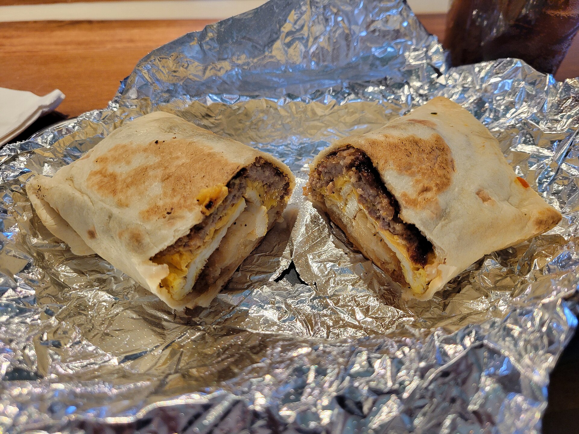Freezer meals for new moms: a breakfast burrito cut in half on foil