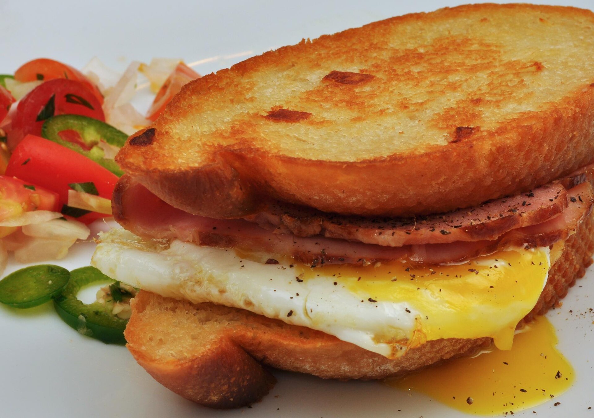 A toasted breakfast sandwich with egg, ham and cheese