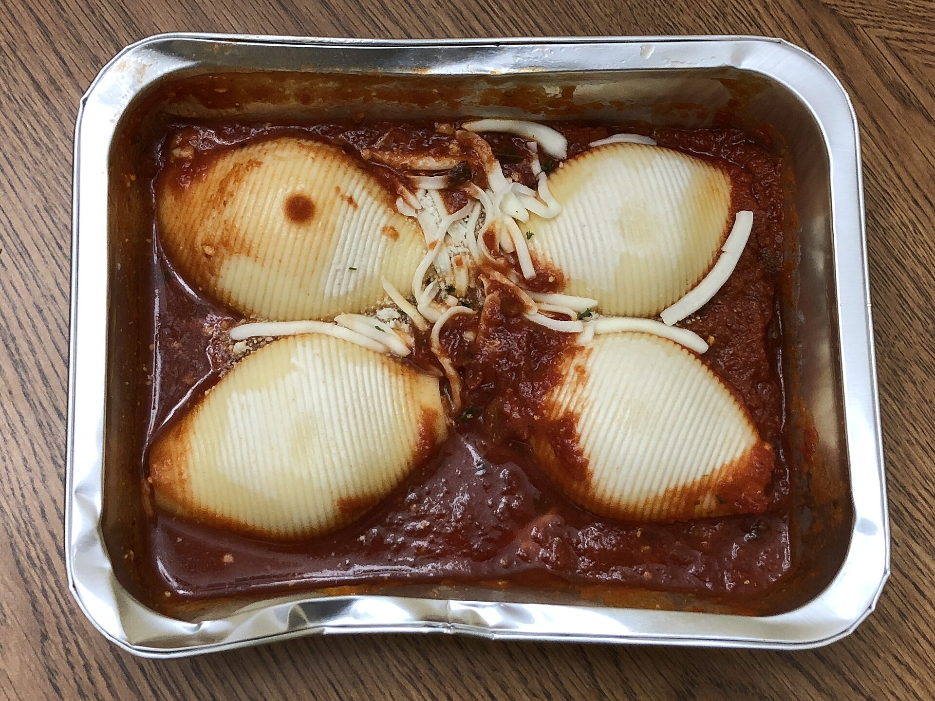 Stuffed pasta shells in tomato sauce in a foil pan