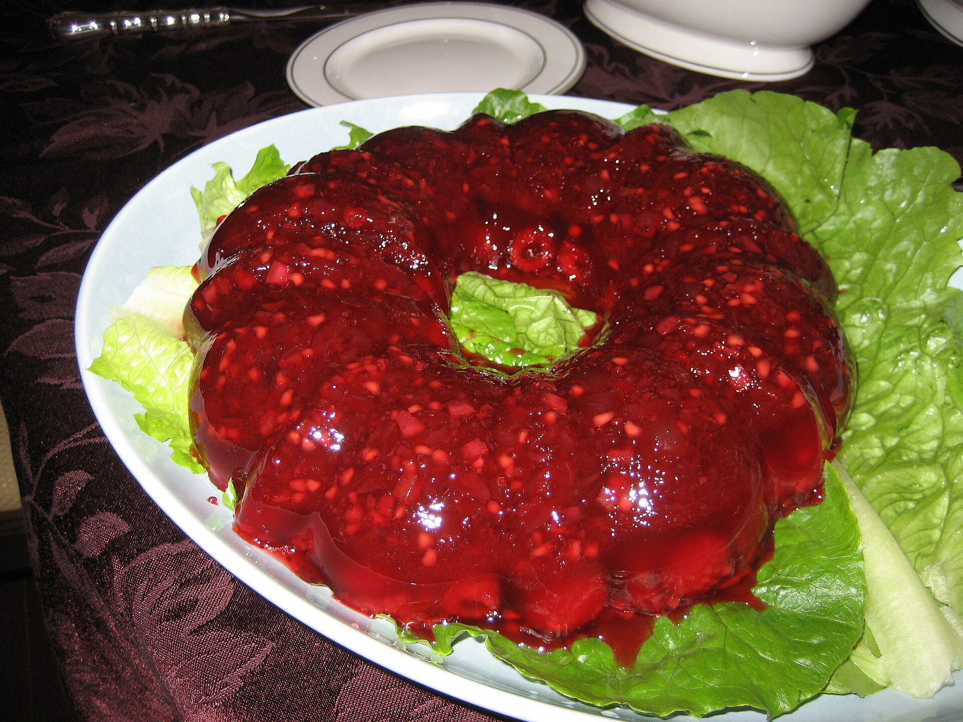 A shiny cranberry gelatin ring salad on a platter