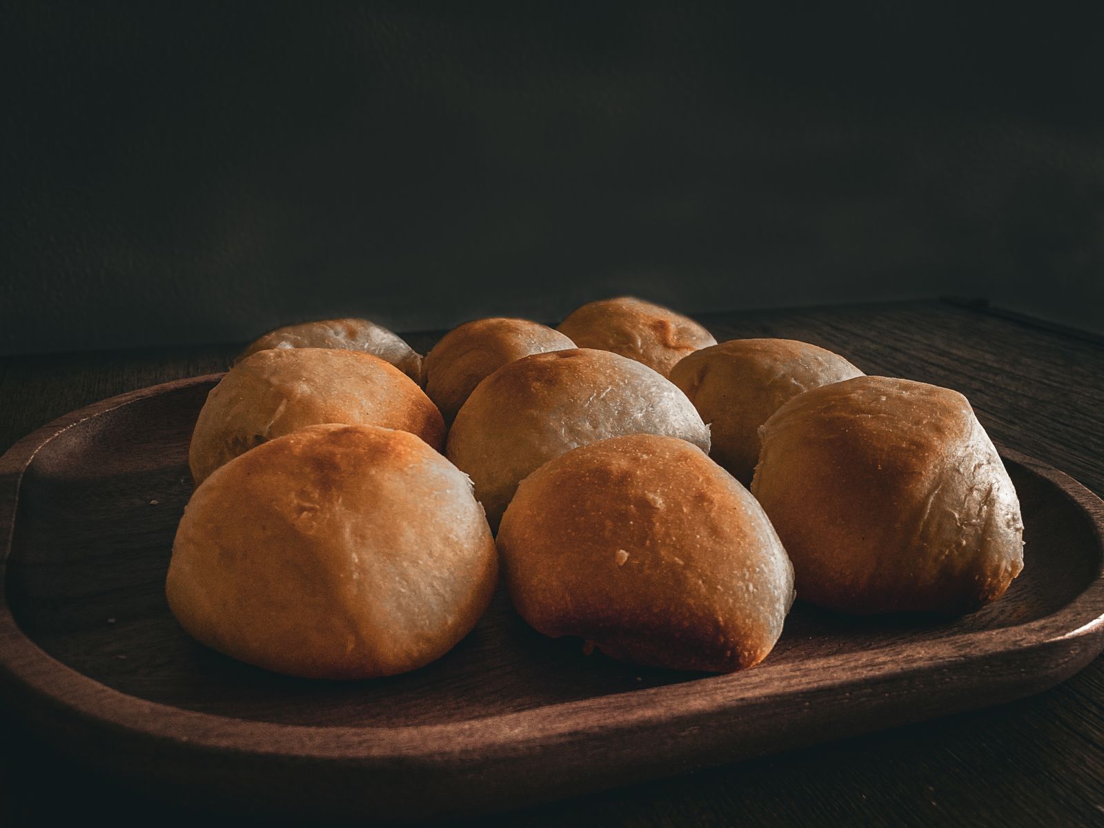 Rustic dinner rolls on a wooden tray